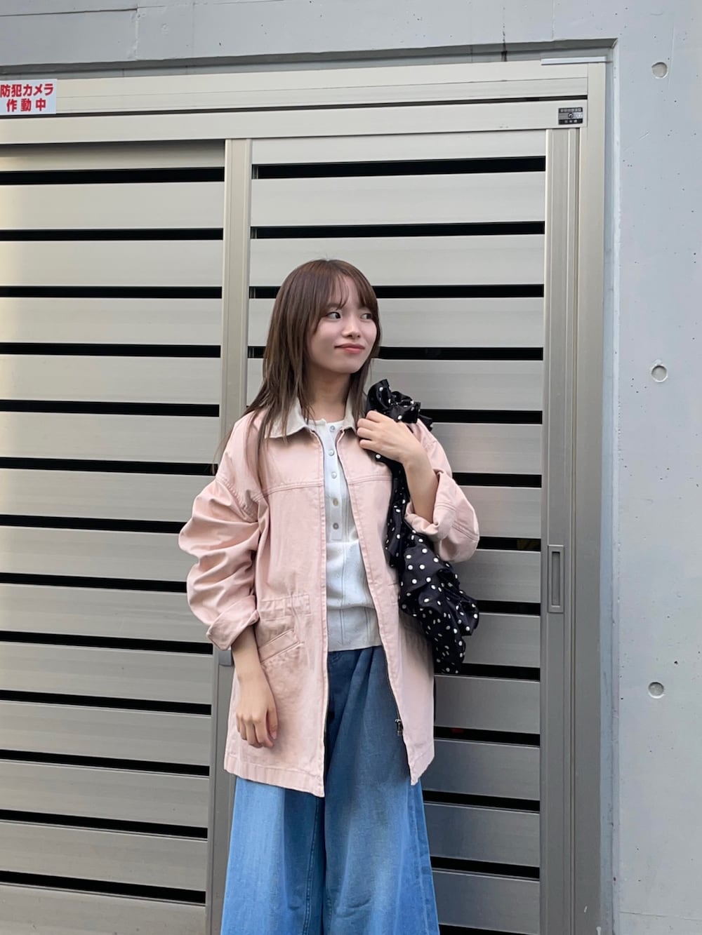 ピンク系のカバーオール、ブラック系のショルダーバッグ、ホワイト系のニット/セーターを着用したレディースの春コーディネートの10枚目の写真