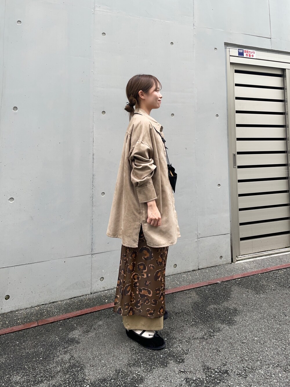 ベージュ系のシャツ/ブラウス、グリーン系のスカート、ブラック系のポーチを着用したレディースの夏コーディネートの5枚目の写真