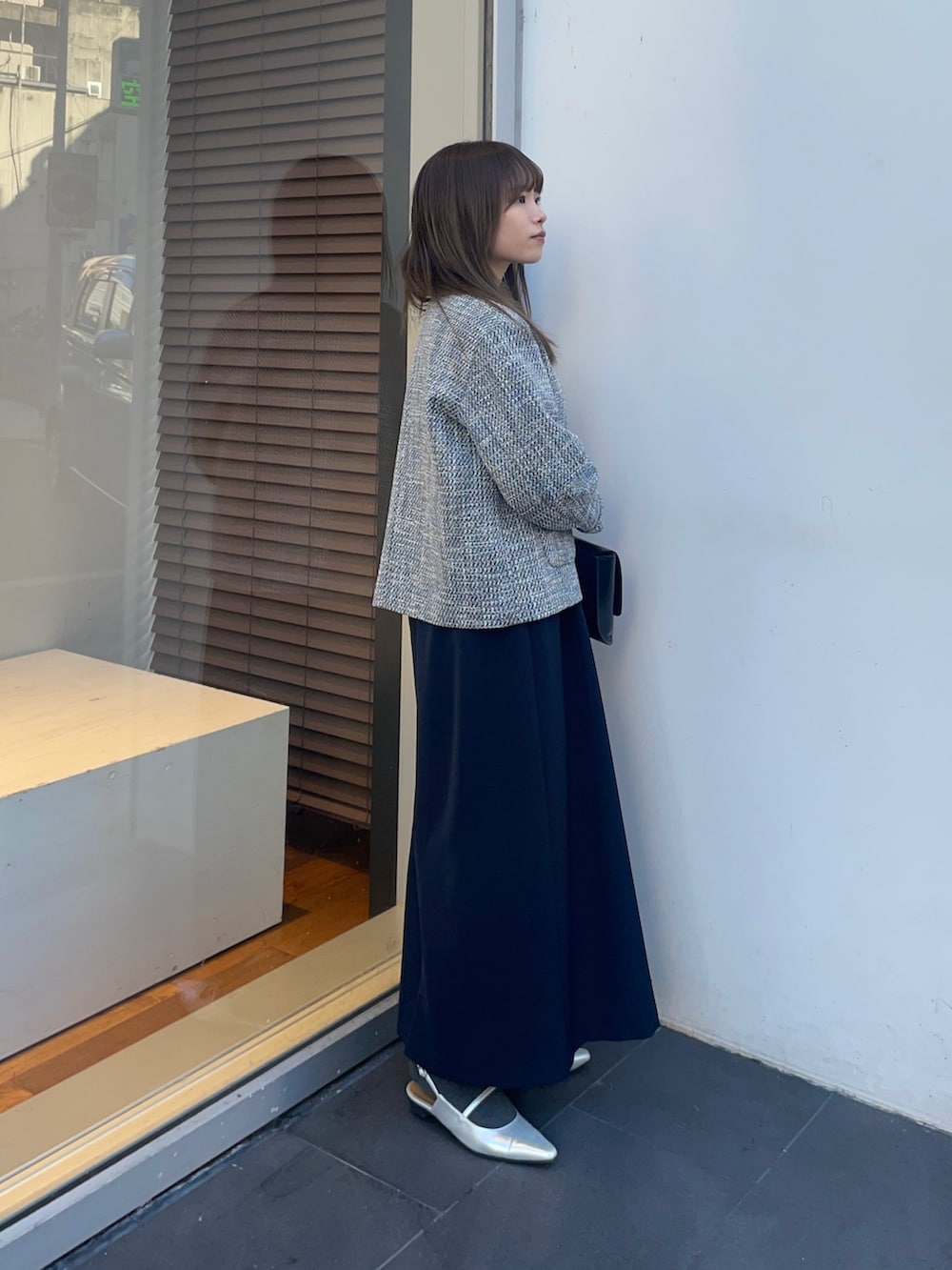 ブラック系のノーカラージャケット、ブルー系のワンピース、シルバー系のパンプスを着用したレディースの冬コーディネートの5枚目の写真