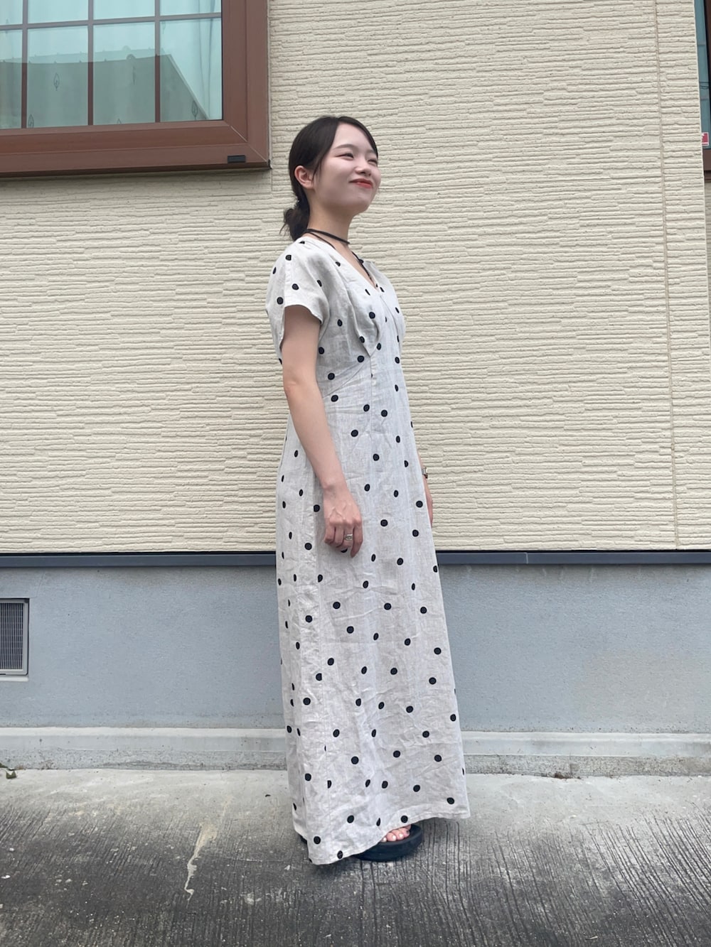 ベージュ系のワンピース、ブラック系のショルダーバッグ、ブラック系のサンダルを着用したレディースの夏コーディネートの5枚目の写真