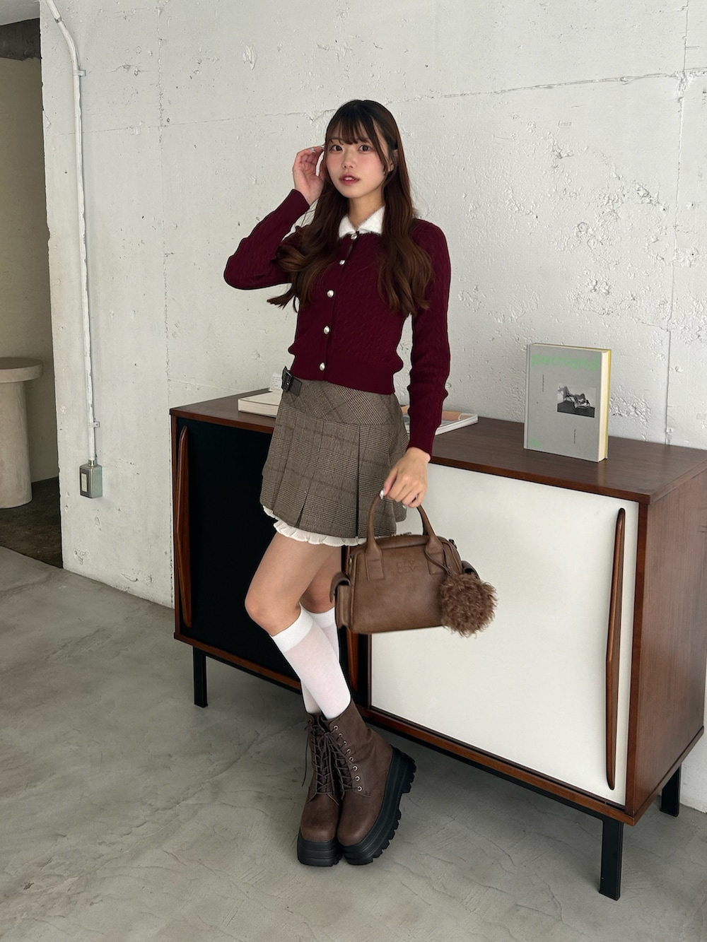ブラウン系のスカート、ブラウン系のショルダーバッグ、レッド系のカーディガン/ボレロを着用したレディースの秋コーディネートの2枚目の写真