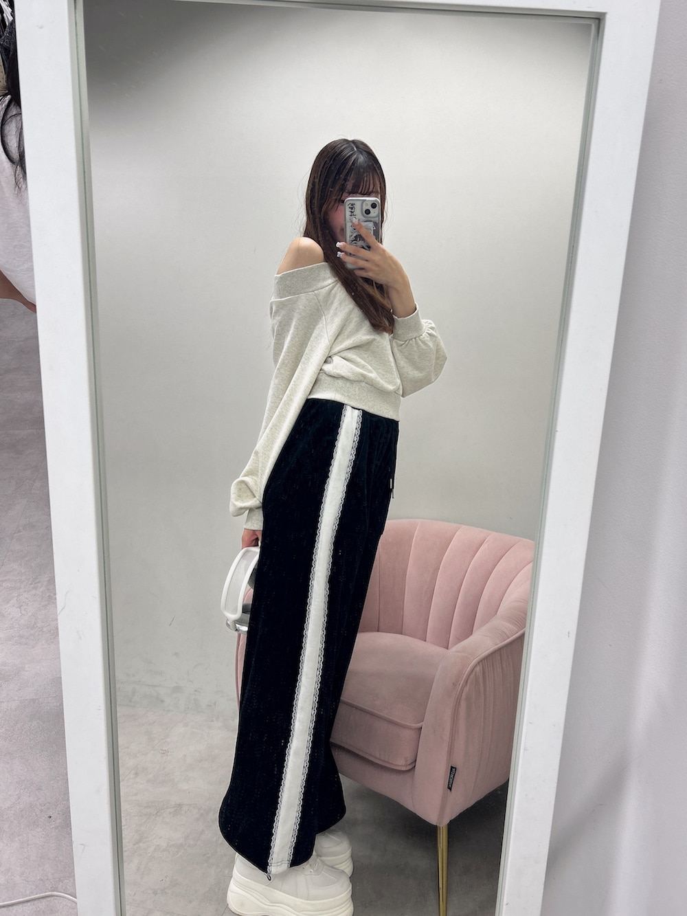 ベージュ系のスウェット、ブラック系のスウェットパンツ、ホワイト系のスニーカーを着用したレディースの夏コーディネートの2枚目の写真