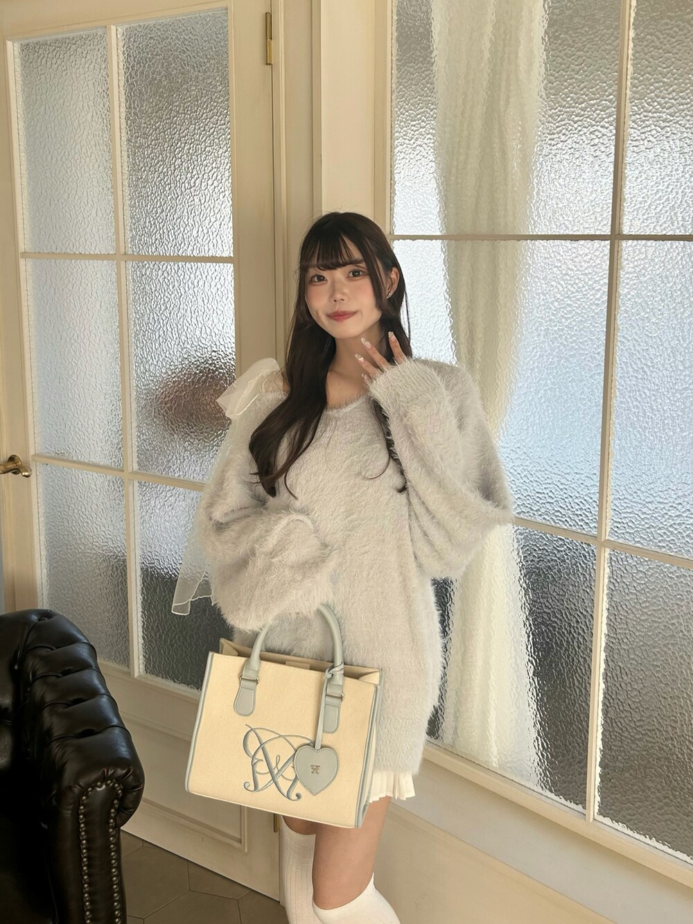 ブルー系のワンピース、ホワイト系のスカート、ホワイト系のスニーカーを着用したレディースの冬コーディネートの3枚目の写真