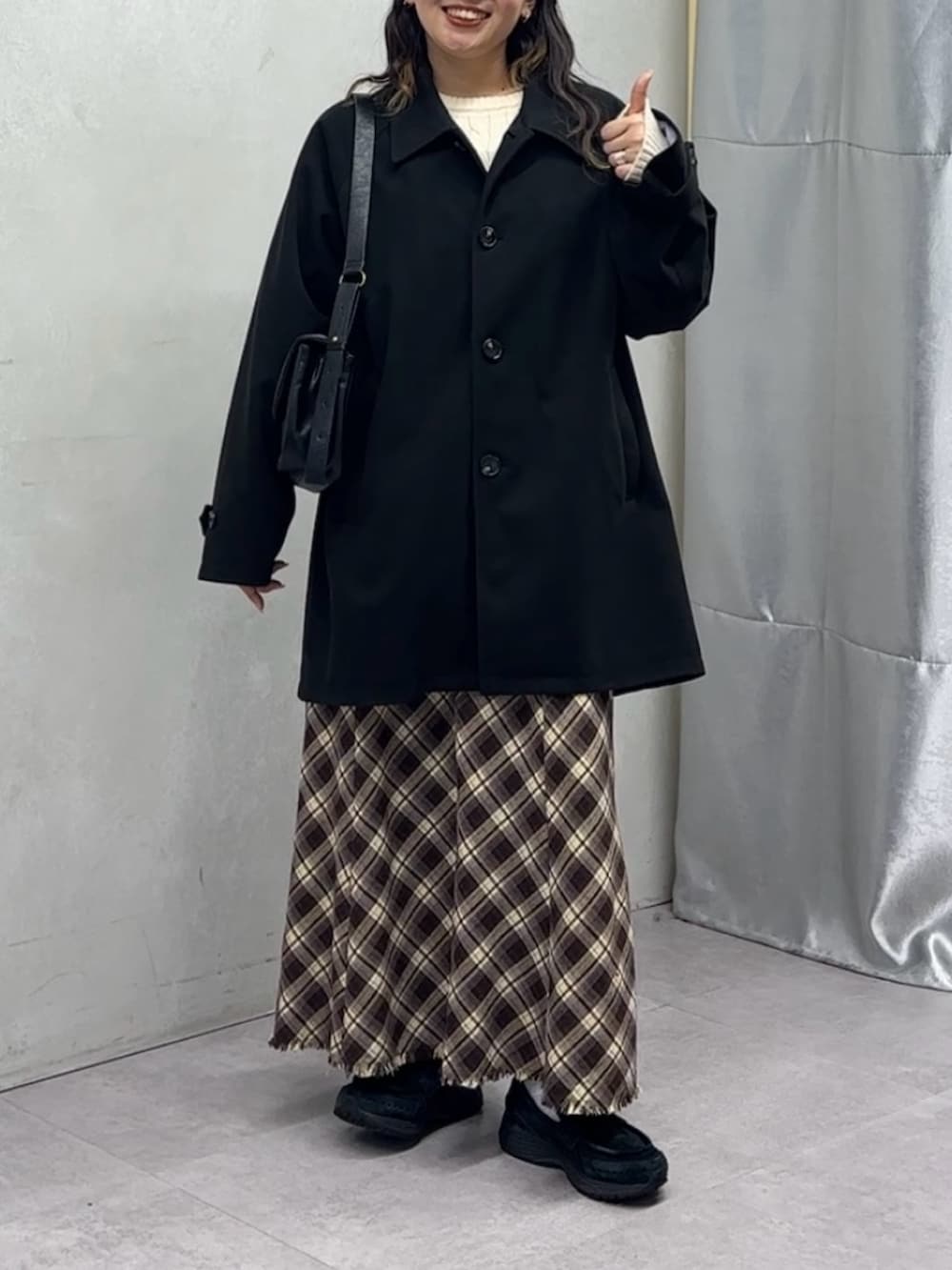 ブラック系のその他アウター、ホワイト系のニット/セーターを着用したレディースの秋コーディネートの2枚目の写真