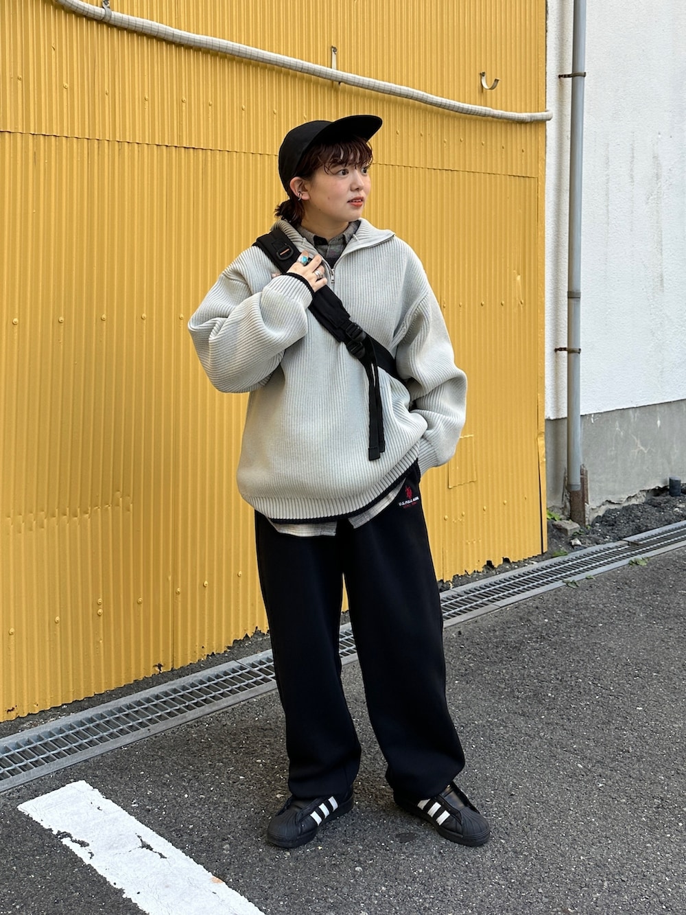 グレー系のニット/セーター、ブラック系のスウェットパンツ、ブラック系のスニーカーを着用したレディースの冬コーディネートの2枚目の写真