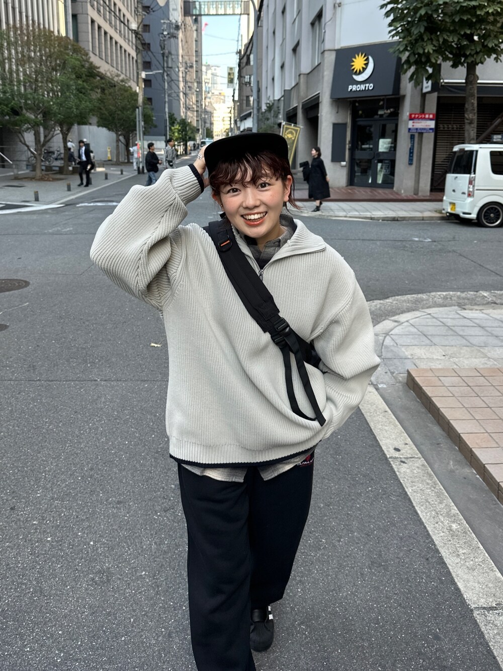 グレー系のニット/セーター、ブラック系のスウェットパンツ、ブラック系のスニーカーを着用したレディースの冬コーディネートの3枚目の写真