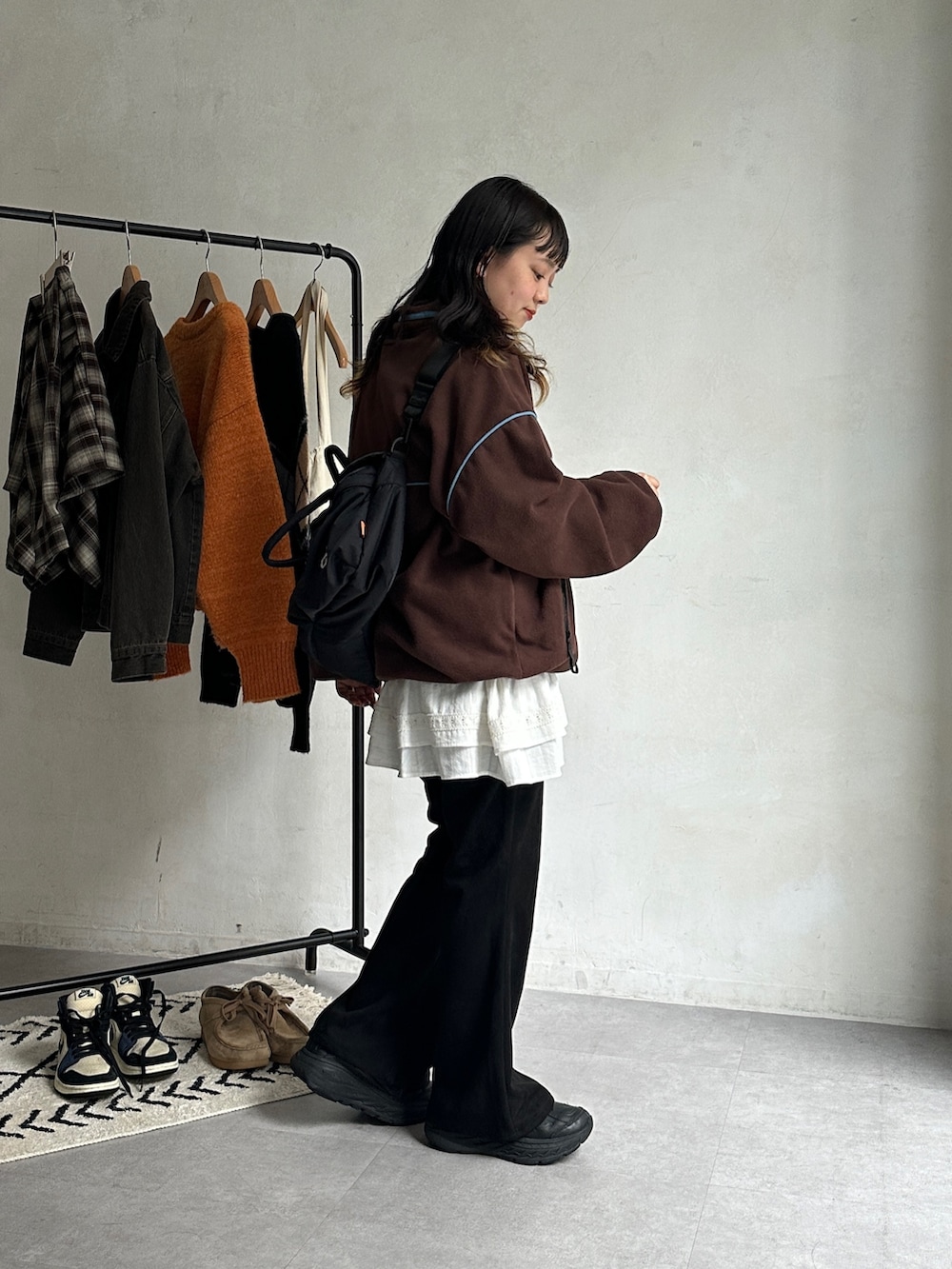 ブラウン系のTシャツ/カットソー、ブラック系のボストンバッグ、ホワイト系のワンピースを着用したレディースの秋コーディネートの2枚目の写真