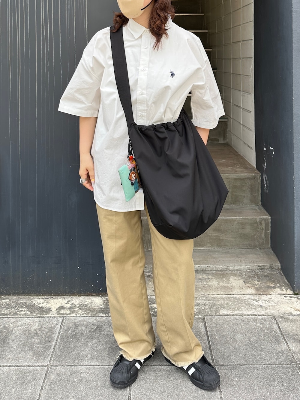 ホワイト系のシャツ/ブラウス、ブラック系のショルダーバッグ、ブラック系のスニーカーを着用したレディースの夏コーディネートの2枚目の写真