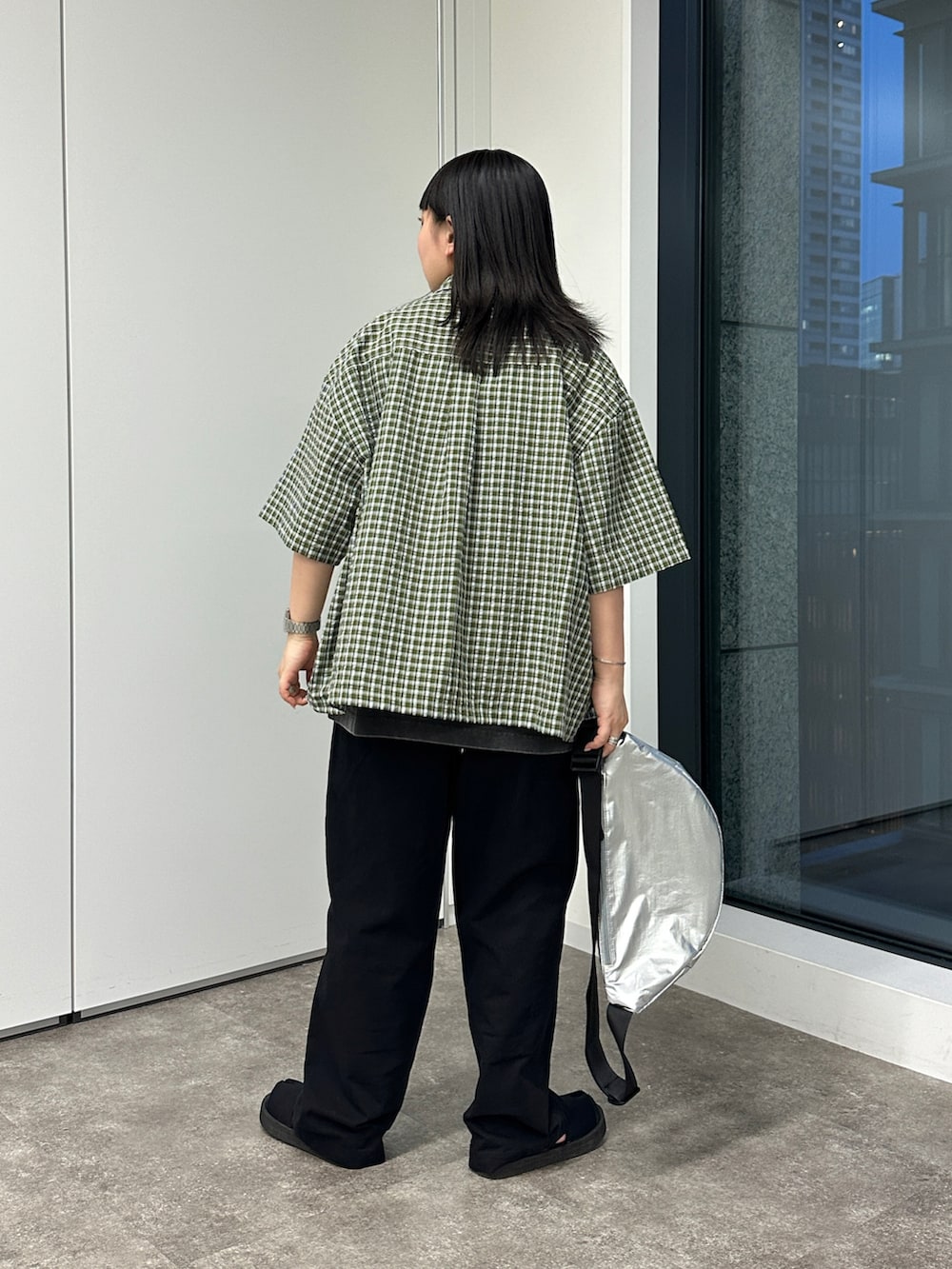 グリーン系のシャツ/ブラウス、ブラック系のその他パンツ、シルバー系のボディバッグ/ウエストポーチを着用したレディースの春コーディネートの3枚目の写真