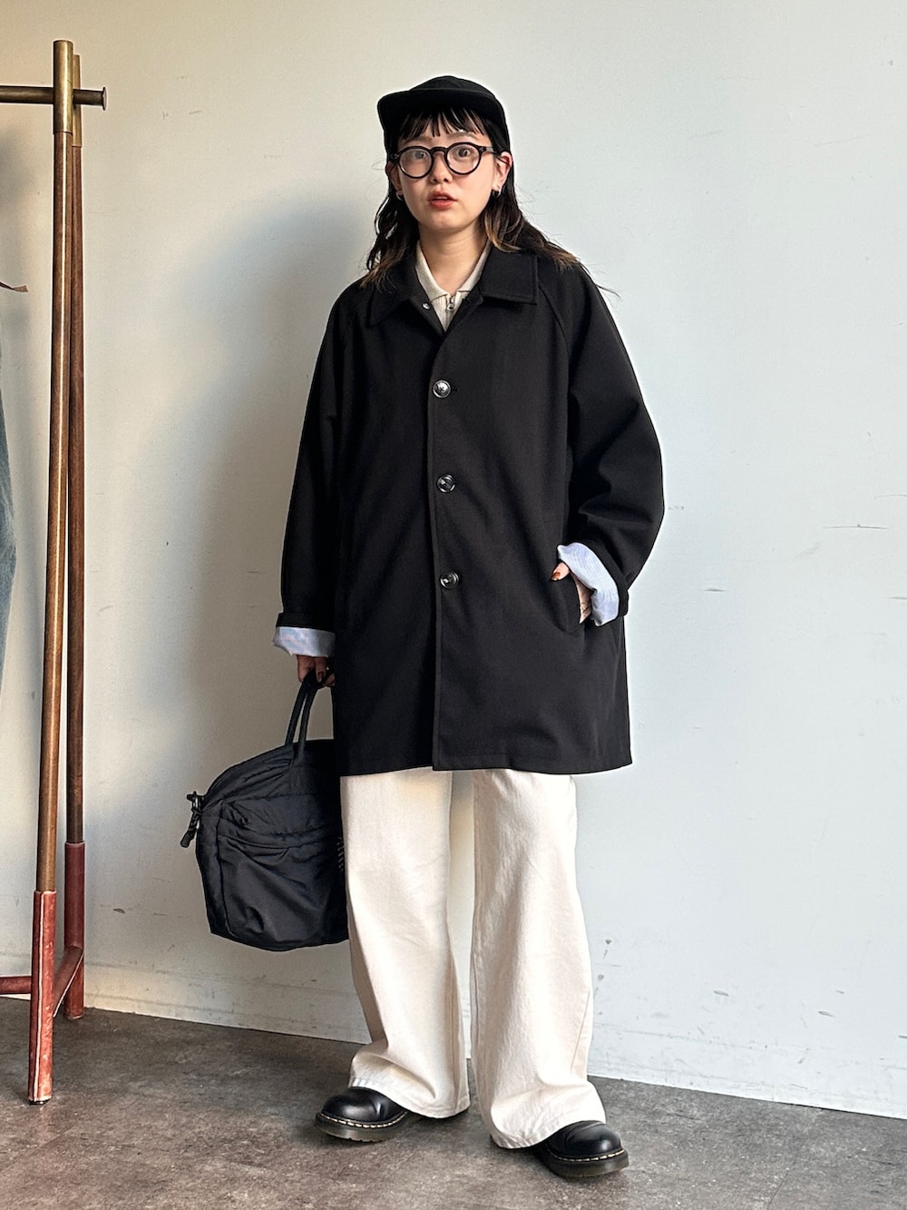 ブラック系のその他アウター、ホワイト系のデニムパンツ、ブラック系のボストンバッグを着用したレディースの秋コーディネートの2枚目の写真