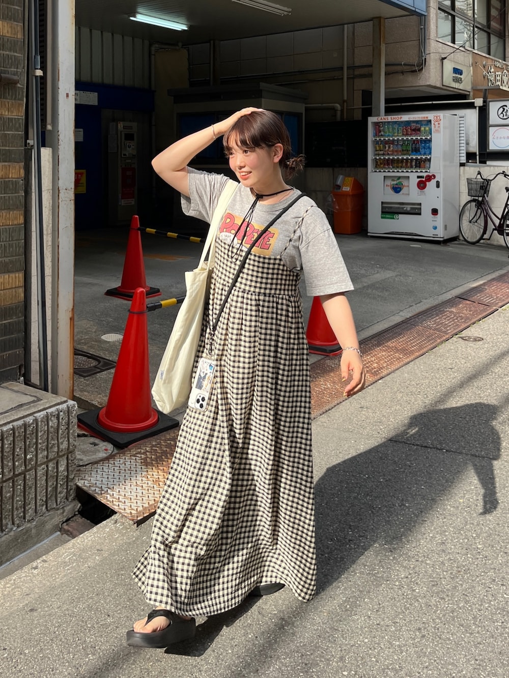 ホワイト系のバッグ、ブラック系のワンピース、ブラック系のハットを着用したレディースの春コーディネートの2枚目の写真