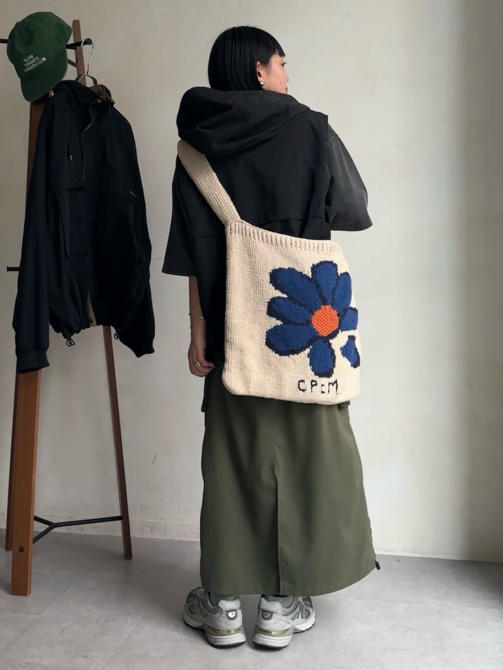 グリーン系のスカート、グレー系のTシャツ/カットソー、ブラック系のベストを着用したレディースの春コーディネートの2枚目の写真