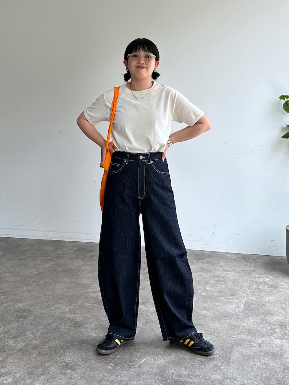 ホワイト系のTシャツ/カットソー、ブルー系のデニムパンツ、オレンジ系のトートバッグを着用したレディースの夏コーディネートの2枚目の写真