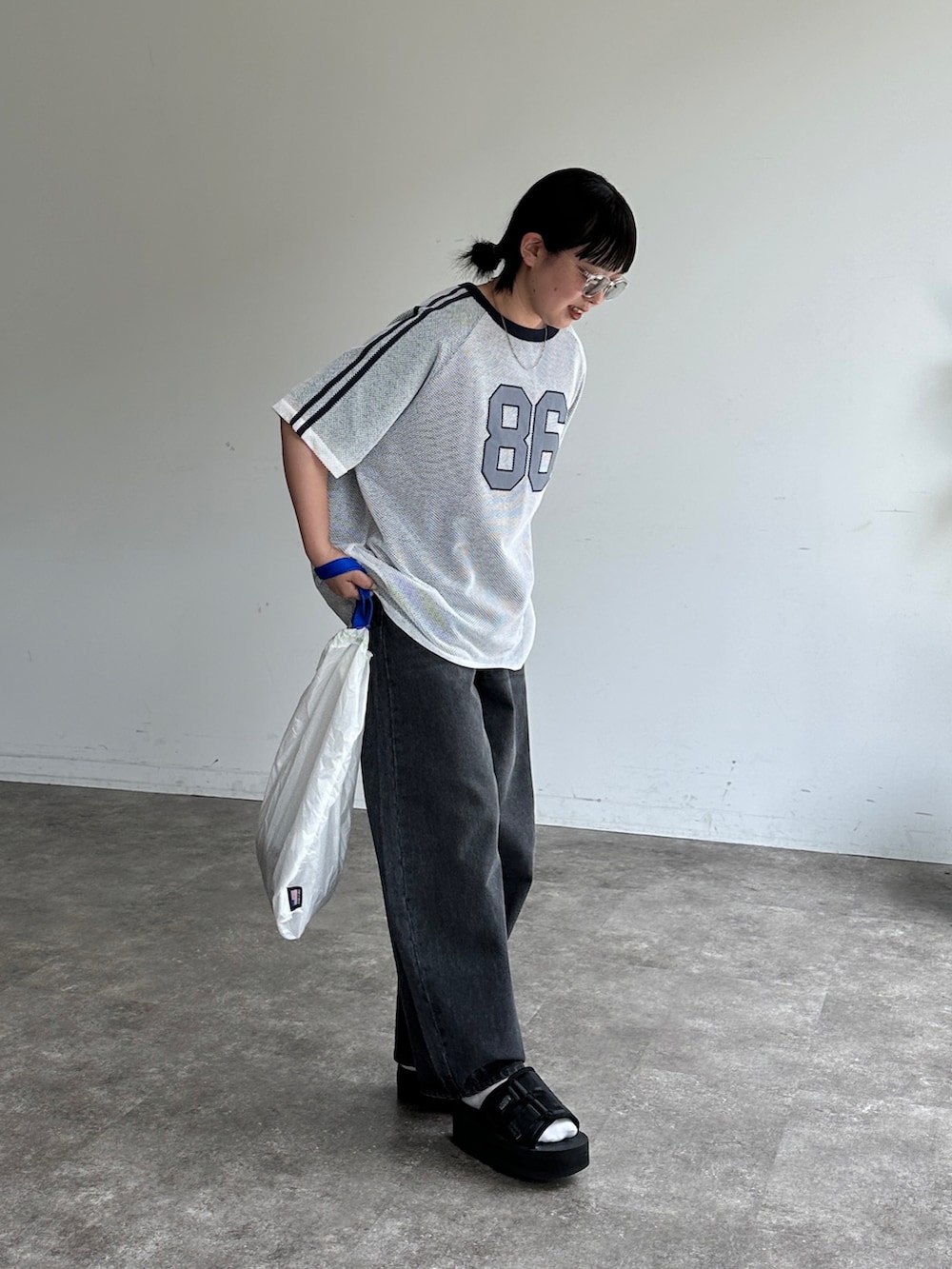 ホワイト系のTシャツ/カットソー、ブラック系のデニムパンツ、ブラック系のサンダルを着用したレディースの夏コーディネートの3枚目の写真