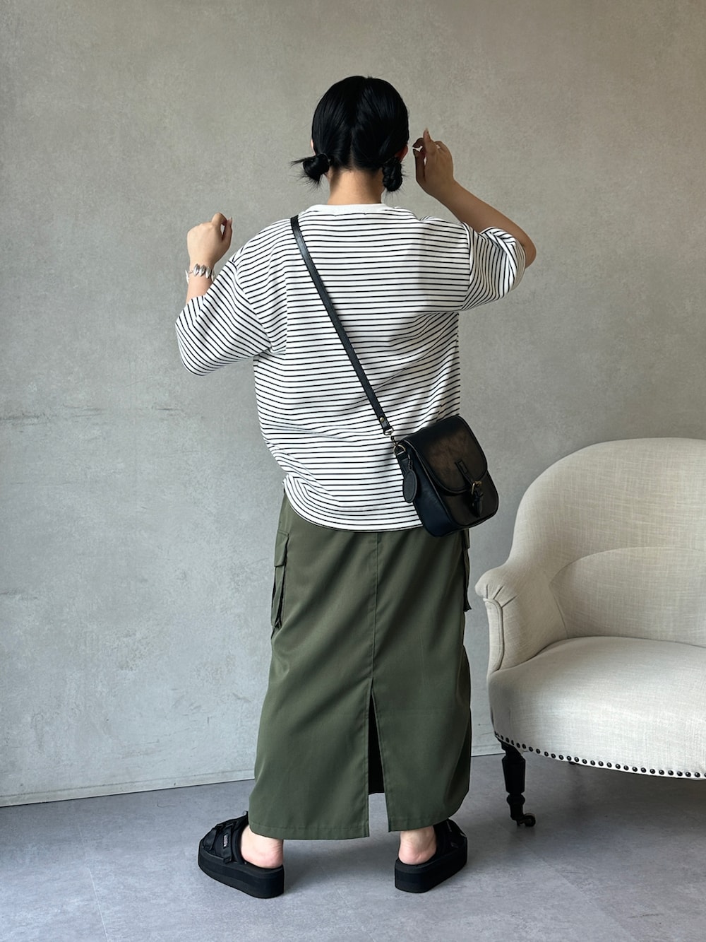 グリーン系のスカート、ブラック系のサンダル、ホワイト系のTシャツ/カットソーを着用したレディースの夏コーディネートの3枚目の写真