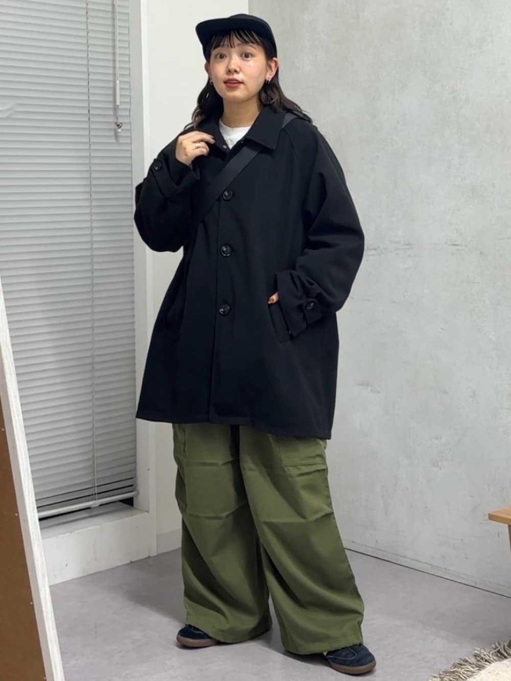 ブラック系のその他アウター、ブラック系のボストンバッグ、グリーン系のカーゴパンツを着用したレディースの秋コーディネートの2枚目の写真
