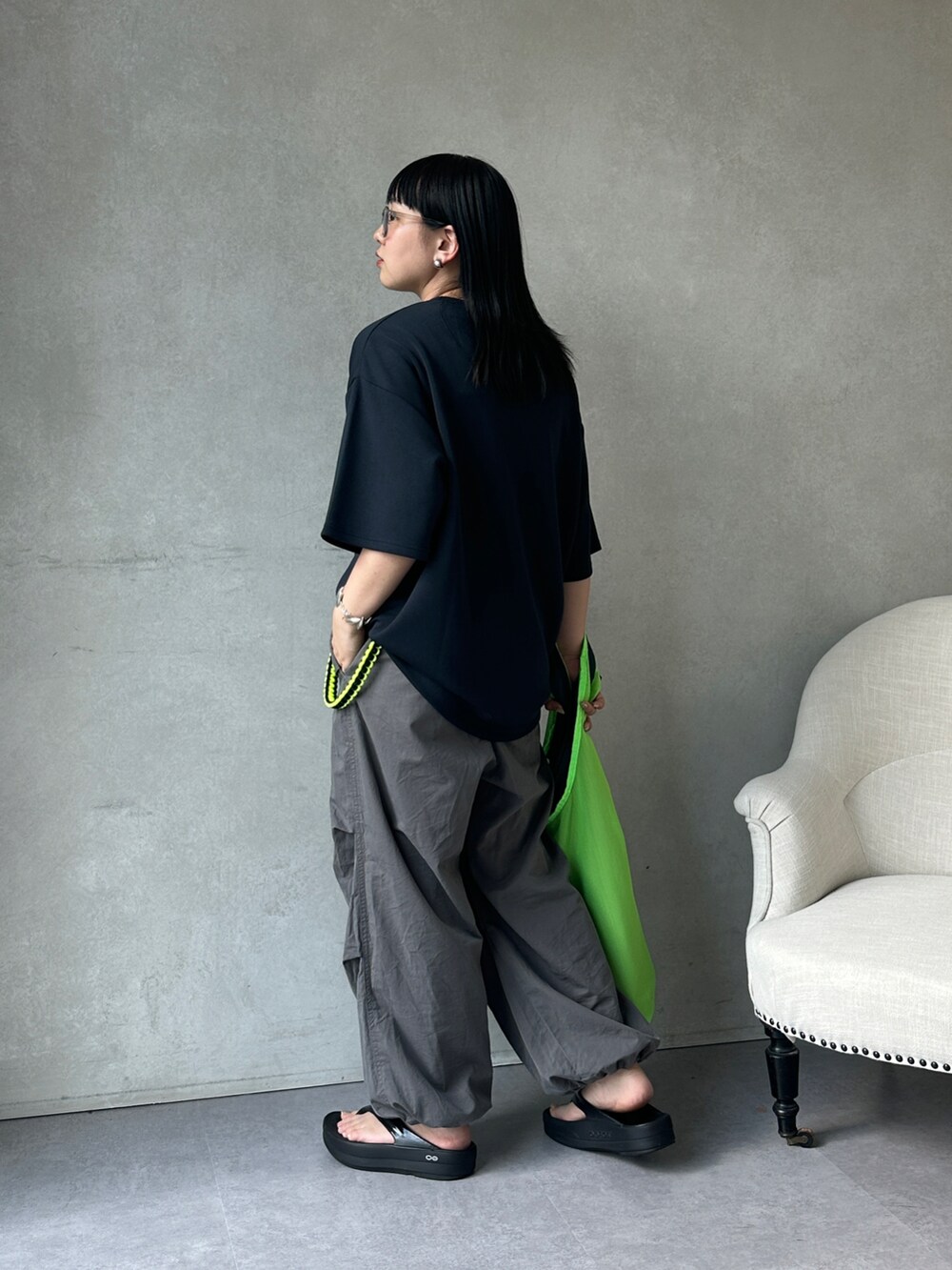 グレー系のその他パンツ、ブラック系のサンダル、ホワイト系のサングラスを着用したレディースの夏コーディネートの2枚目の写真