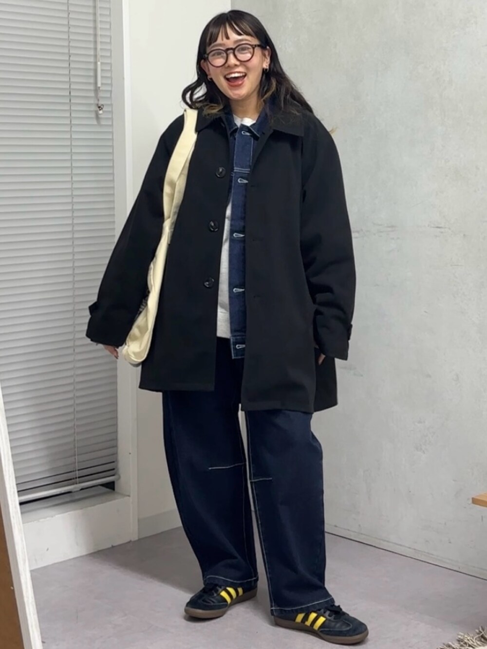 ブラック系のその他アウター、ホワイト系のトートバッグ、ブルー系のデニムパンツを着用したレディースの秋コーディネートの2枚目の写真