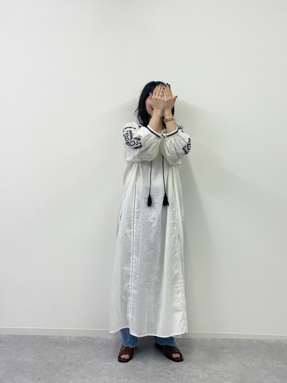 ホワイト系のシャツワンピースを着用したレディースの夏コーディネートの2枚目の写真