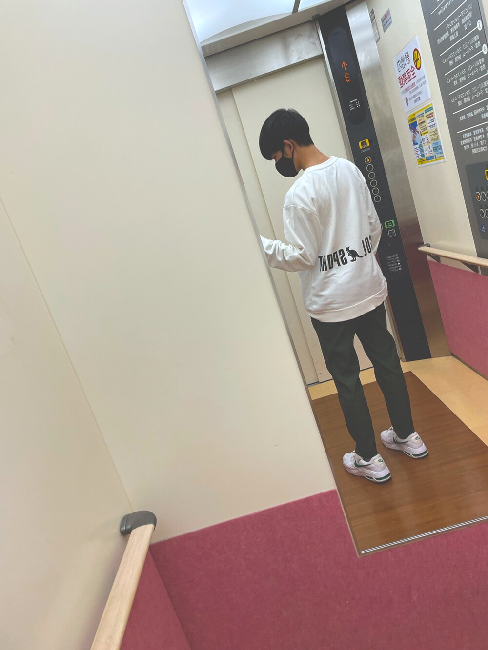 グリーン系のパンツ、ホワイト系のスニーカー、ホワイト系のスウェットを着用したメンズの秋コーディネートの2枚目の写真