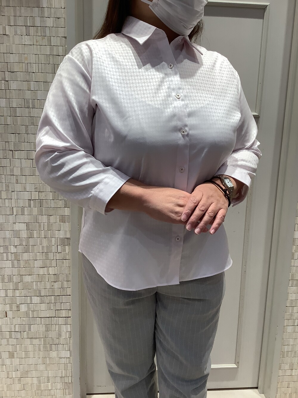 ピンク系のビジネスシャツを着用したレディースの夏コーディネートの2枚目の写真