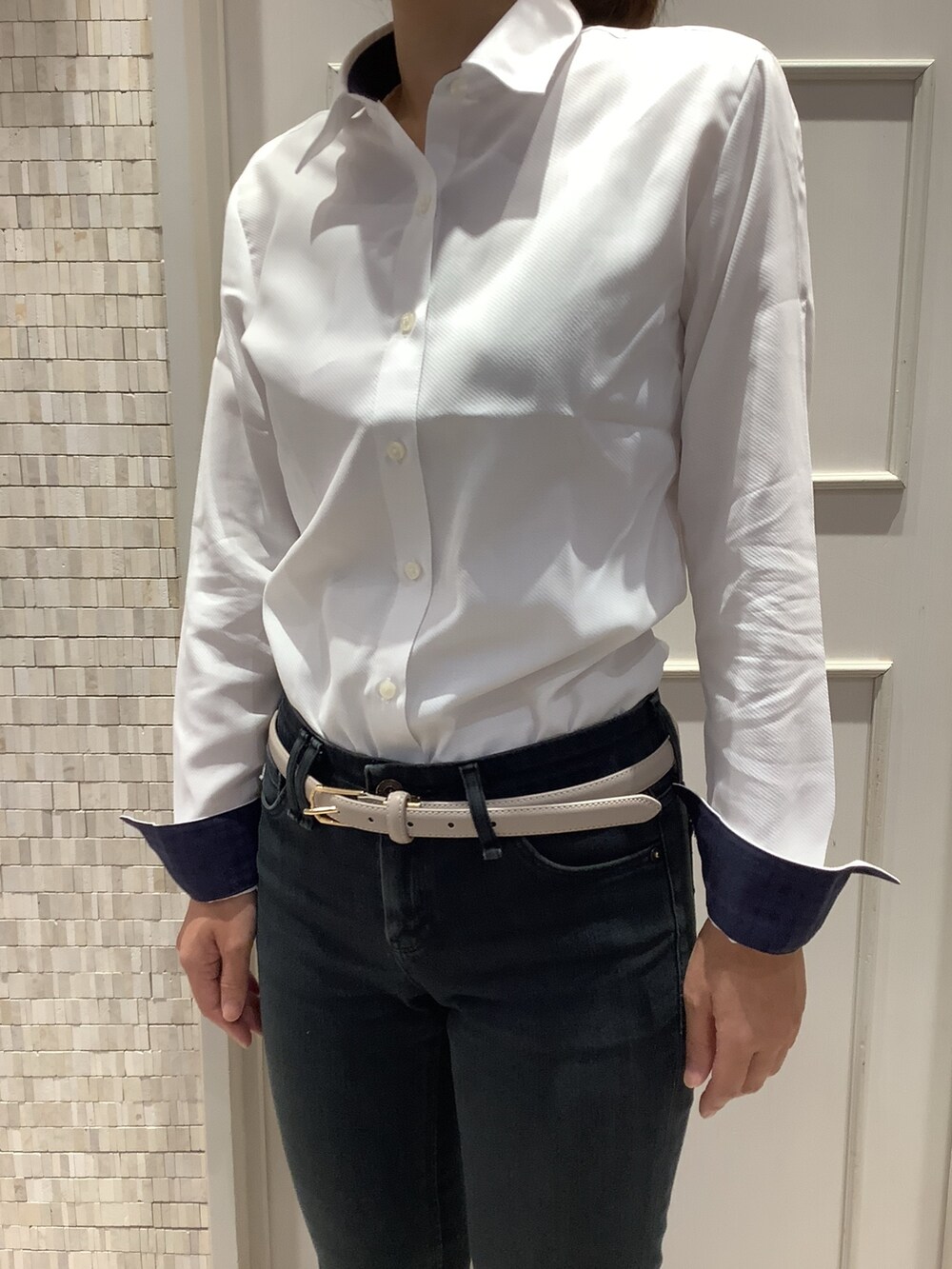 ホワイト系のビジネスシャツを着用したレディースの秋コーディネートの2枚目の写真