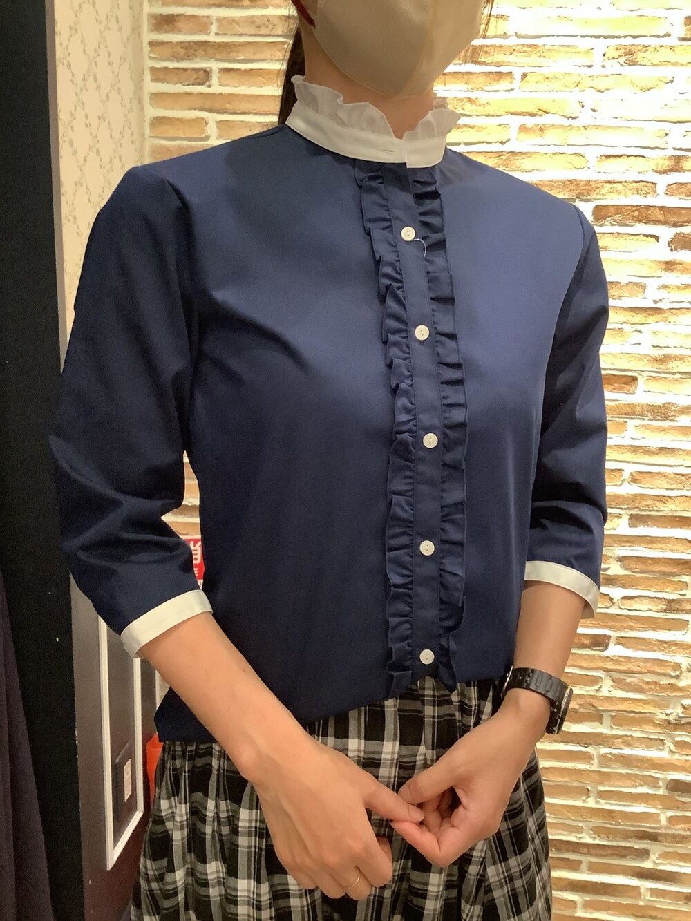 ブルー系のビジネスシャツを着用したレディースの春コーディネートの2枚目の写真