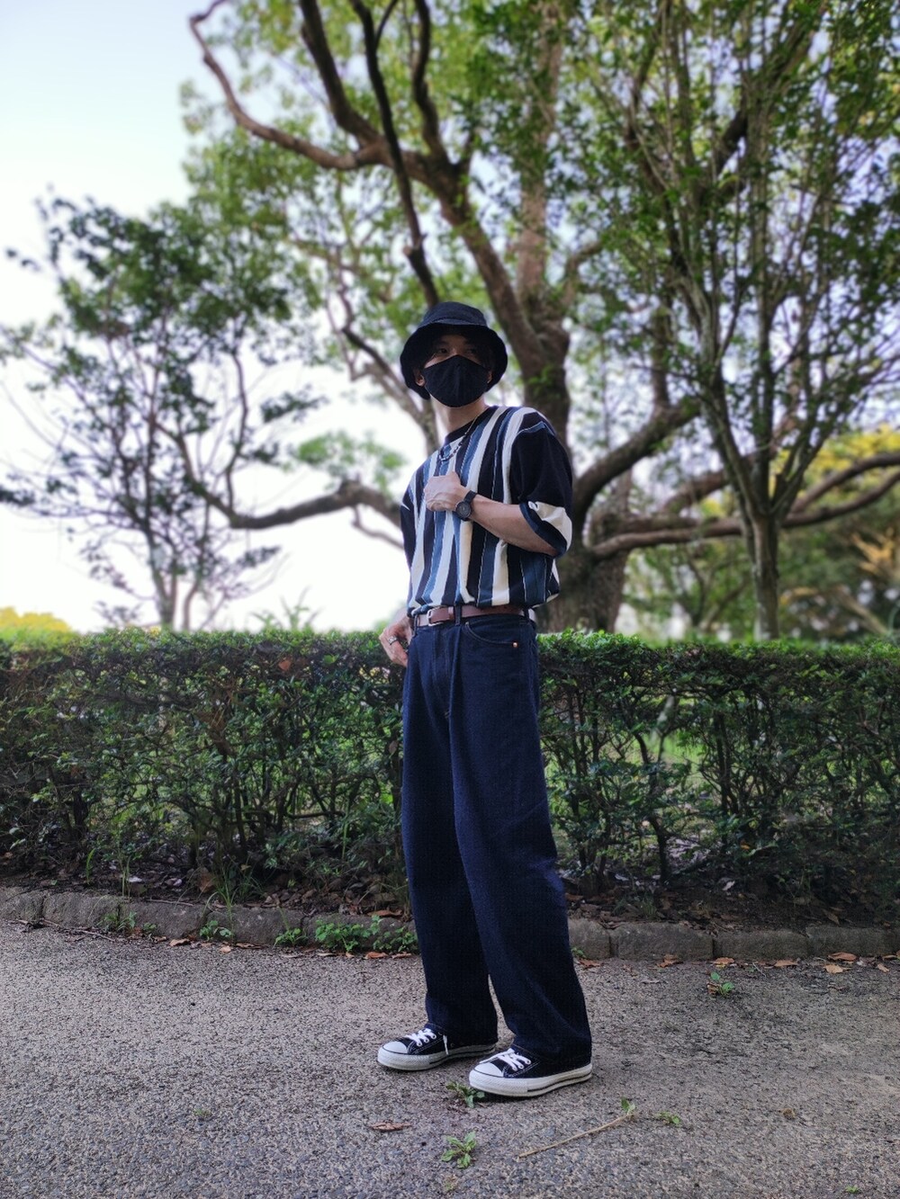 ブルー系のデニムパンツ、ブラック系のスニーカー、その他のTシャツ/カットソーを着用したメンズの夏コーディネートの4枚目の写真