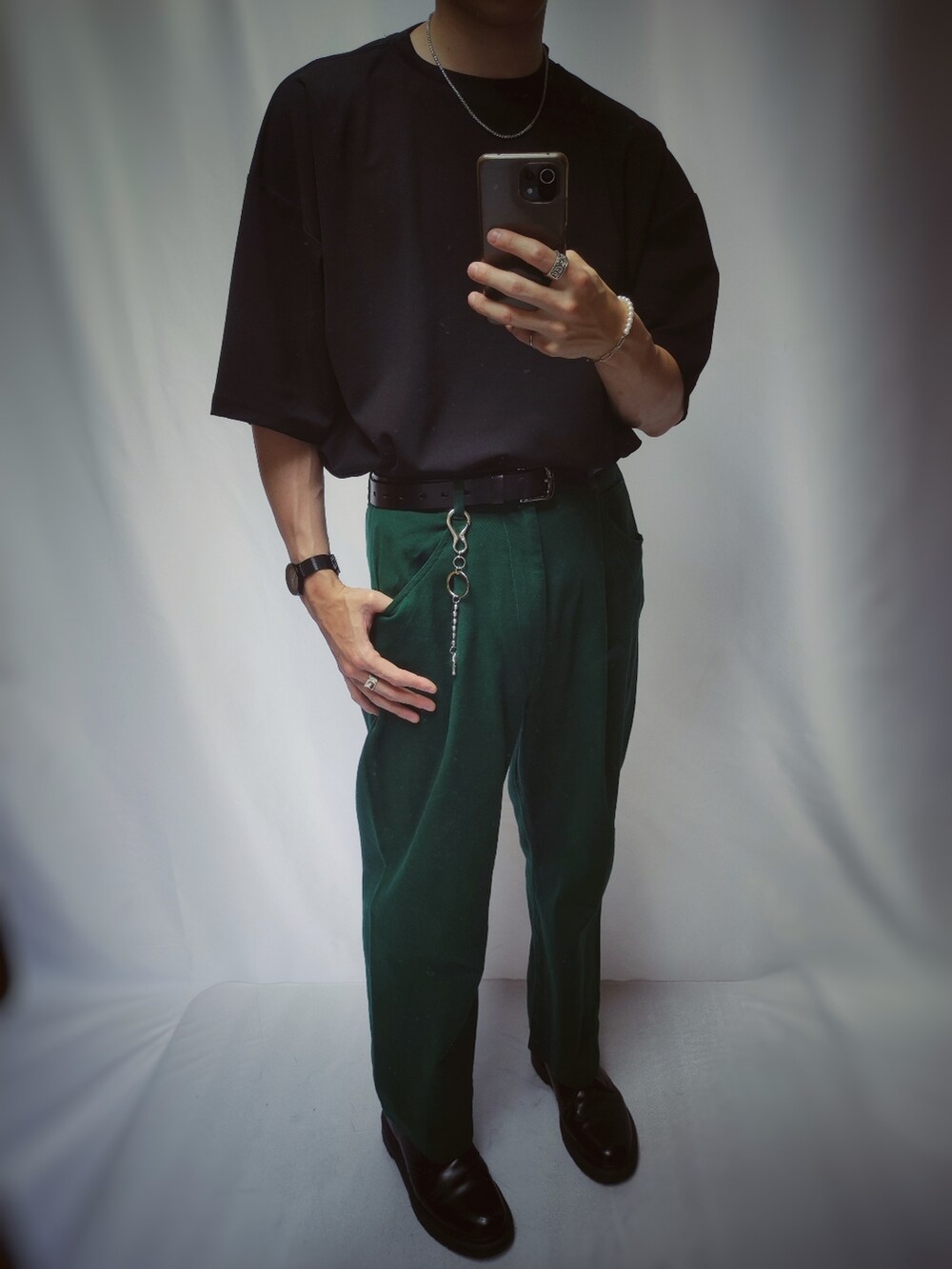 ブラック系のドレスシューズ、ブラック系のTシャツ/カットソー、グリーン系のチノパンツを着用したメンズの夏コーディネートの2枚目の写真