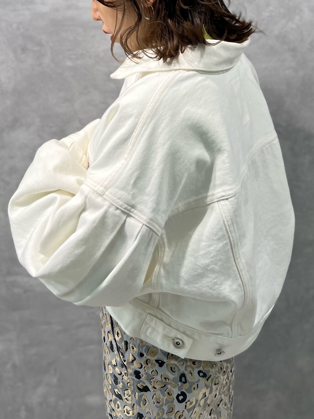 ホワイト系のデニムジャケット、グリーン系のニット/セーター、ベージュ系のスカートを着用したレディースの冬コーディネートの7枚目の写真