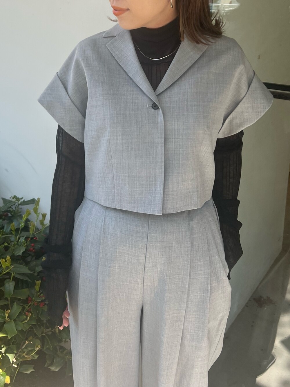 グレー系のテーラードジャケット、グレー系のスラックス、ブラック系のパンプスを着用したレディースの春コーディネートの4枚目の写真