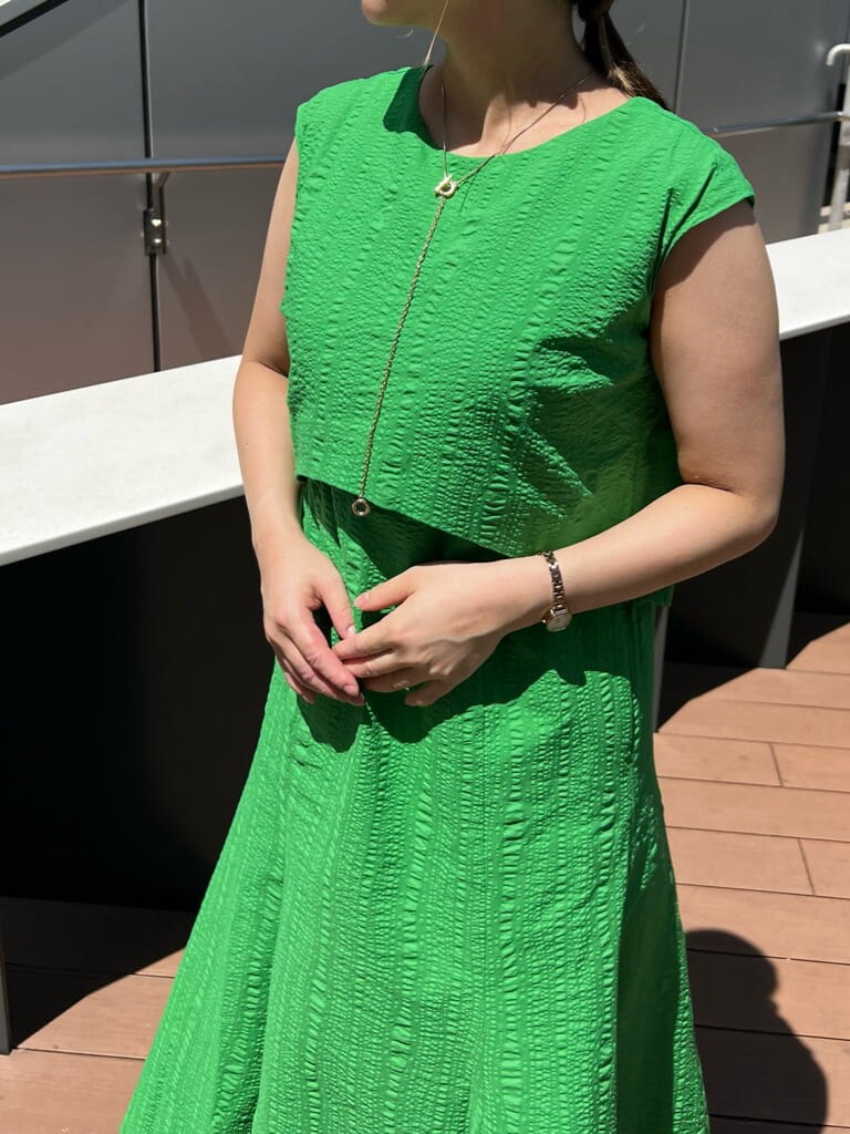 ブラック系のショルダーバッグ、グリーン系のワンピース、ブラック系のサンダルを着用したレディースの夏コーディネートの5枚目の写真