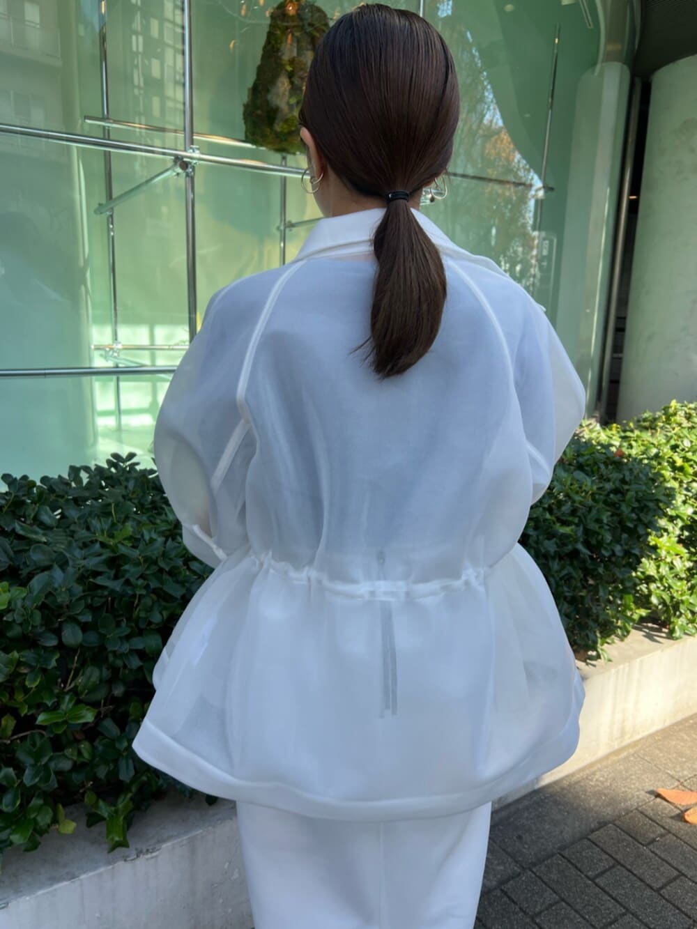 ホワイト系のその他アウター、ブルー系のニット/セーター、ホワイト系のスカートを着用したレディースの秋コーディネートの6枚目の写真