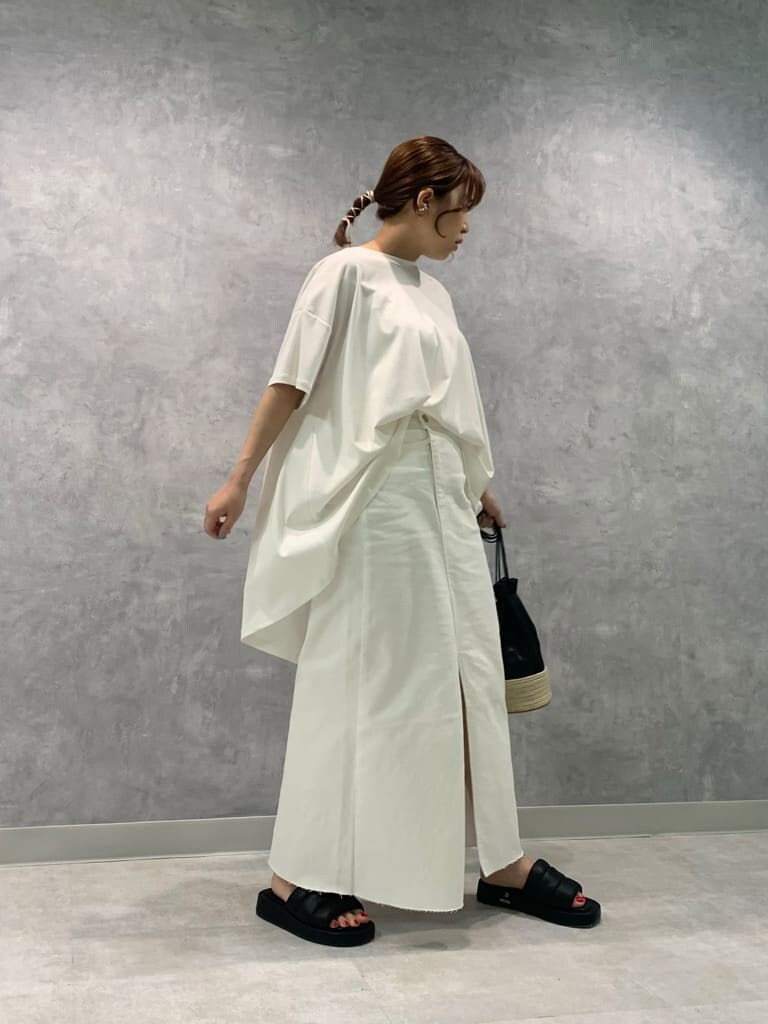 ブラック系のハンドバッグ、ホワイト系のデニムスカート、ブラック系のサンダルを着用したレディースの夏コーディネートの3枚目の写真