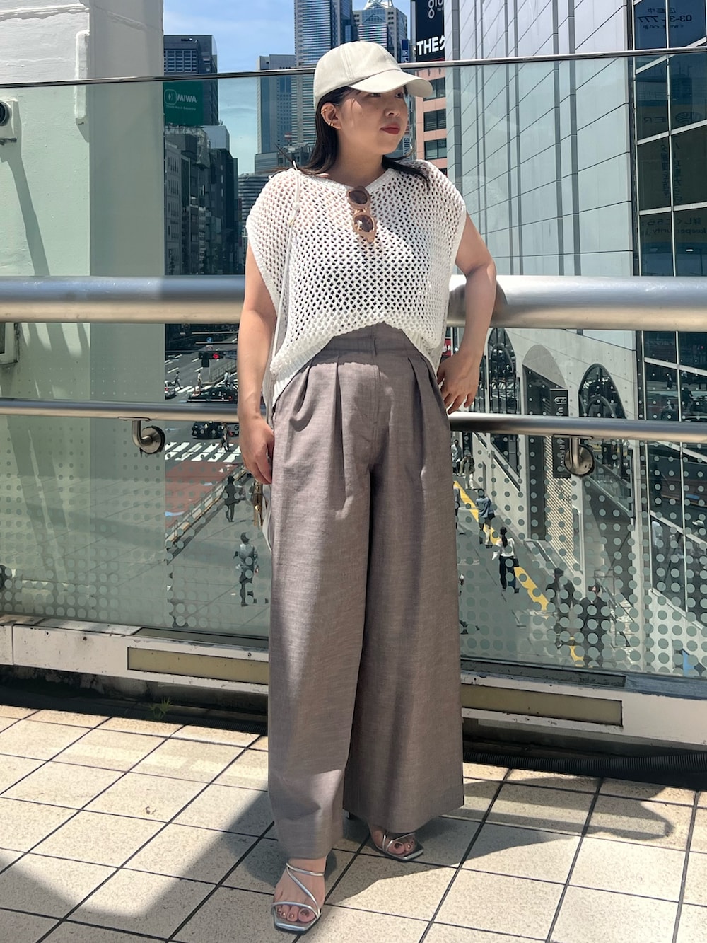 ホワイト系のニット/セーター、ブラウン系のその他パンツ、ホワイト系のショルダーバッグを着用したレディースの夏コーディネートの2枚目の写真