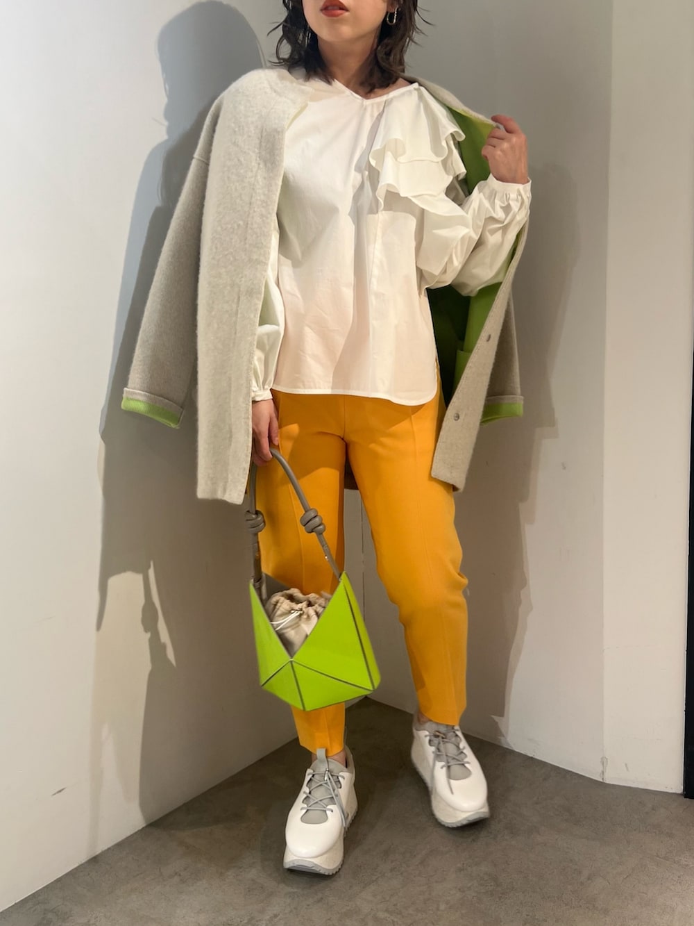 ホワイト系のシャツ/ブラウス、イエロー系のハンドバッグ、オレンジ系のその他パンツを着用したレディースの冬コーディネートの5枚目の写真