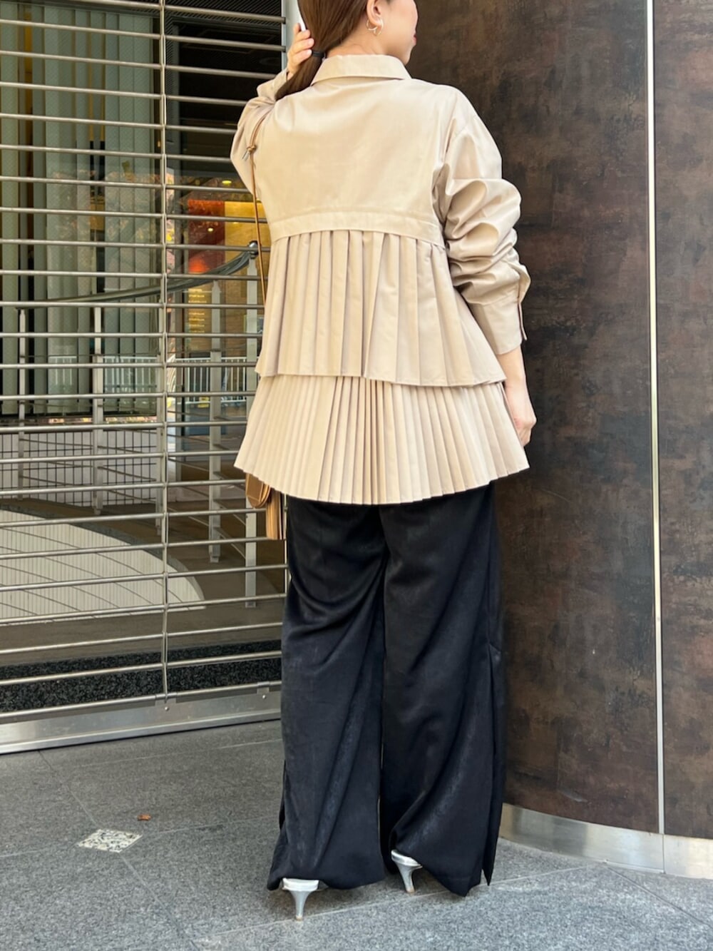 ベージュ系のシャツ/ブラウス、シルバー系のパンプス、ゴールド系のイヤーカフを着用したレディースの冬コーディネートの3枚目の写真