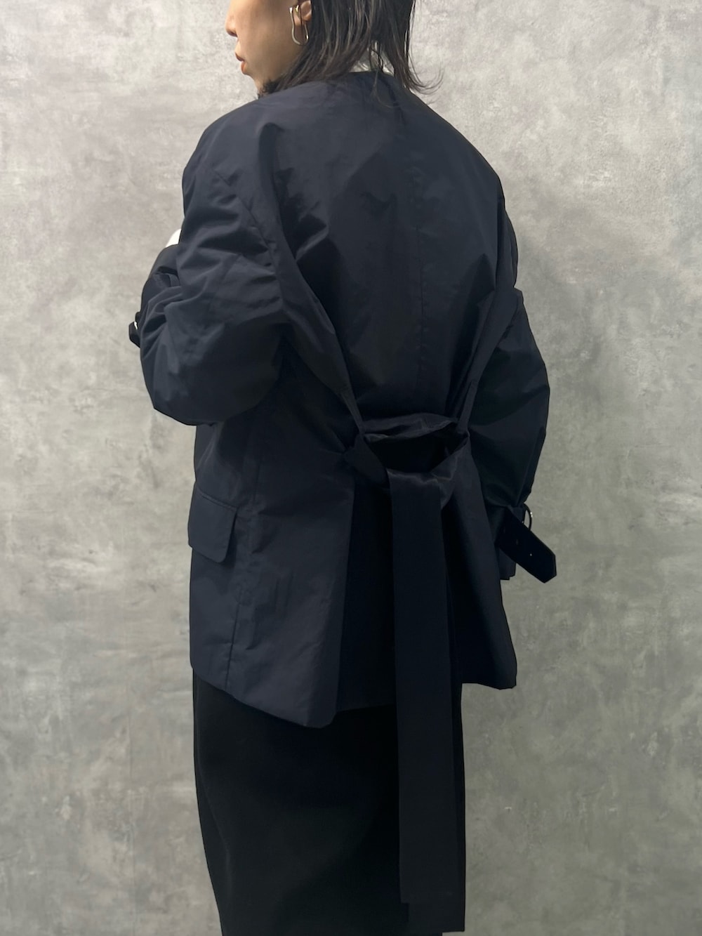 ブルー系のノーカラージャケット、ホワイト系のシャツ/ブラウス、ブラック系のスカートを着用したレディースの春コーディネートの5枚目の写真