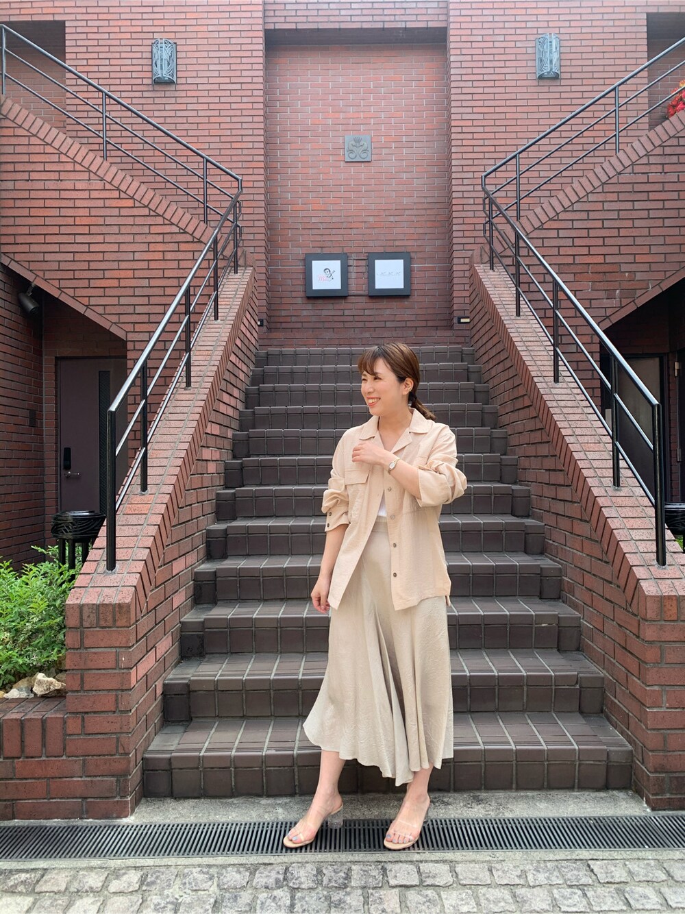 ブラウン系のスカート、ベージュ系のシャツ/ブラウスを着用したレディースの春コーディネートの6枚目の写真