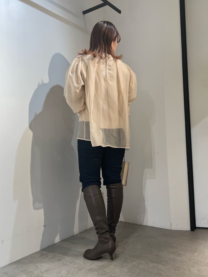 ブルー系のデニムパンツ、ベージュ系のショルダーバッグ、ブラウン系のニット/セーターを着用したレディースの秋コーディネートの7枚目の写真