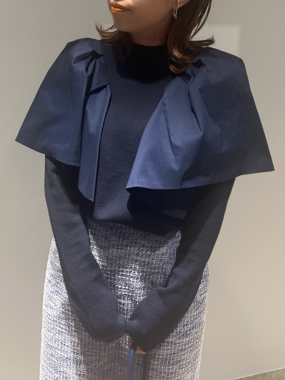 ブラック系のブーツ、ブルー系のニット/セーター、ブルー系のスカートを着用したレディースの春コーディネートの3枚目の写真