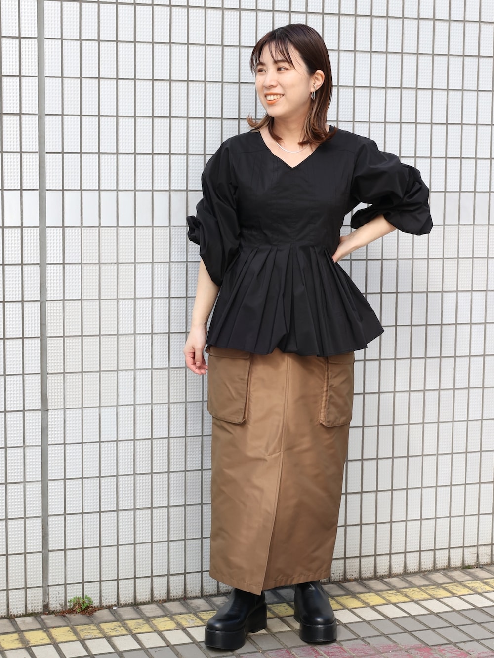 ブラウン系のスカート、ブラック系のシャツ/ブラウスを着用したレディースの春コーディネートの3枚目の写真