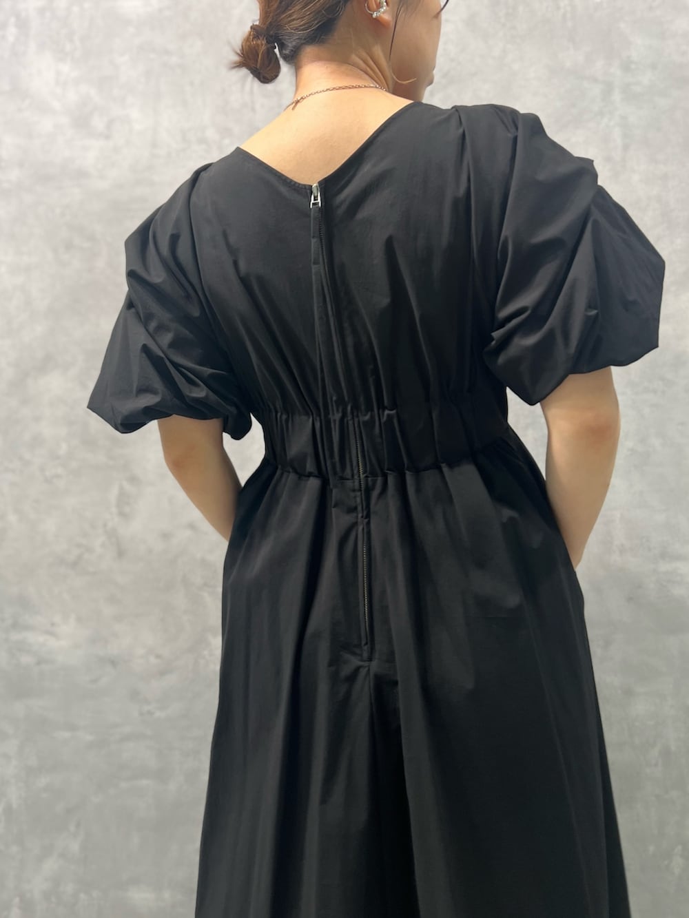 ブラック系のワンピース、ブラック系のサンダル、シルバー系のネックレスを着用したレディースの春コーディネートの6枚目の写真