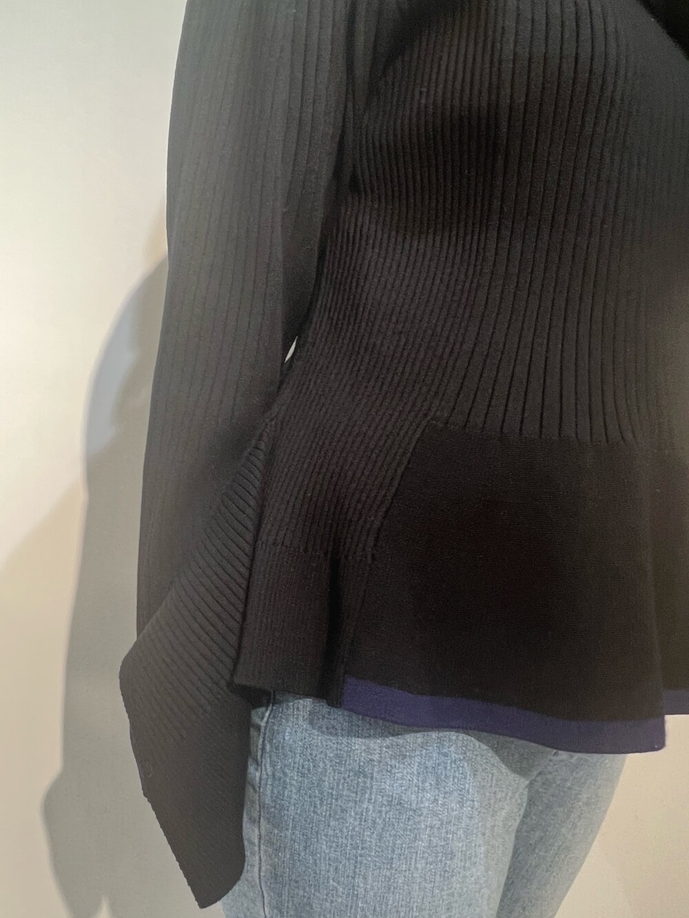 ベージュ系のトレンチコート、ブラック系のニット/セーター、ブルー系のデニムパンツを着用したレディースの冬コーディネートの9枚目の写真