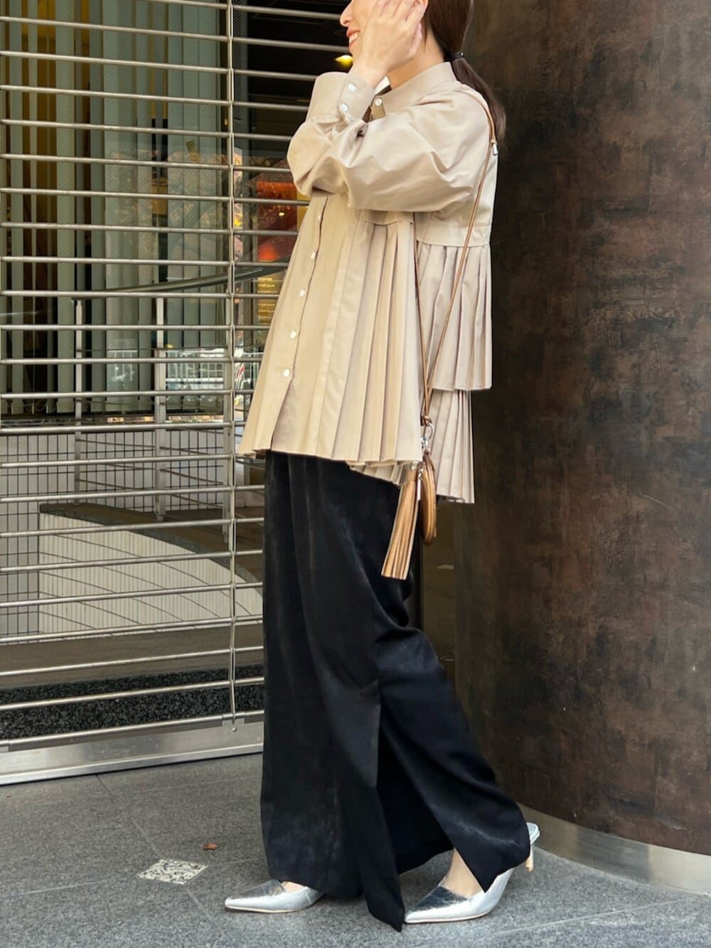 ベージュ系のシャツ/ブラウス、シルバー系のパンプス、ゴールド系のイヤーカフを着用したレディースの冬コーディネートの2枚目の写真