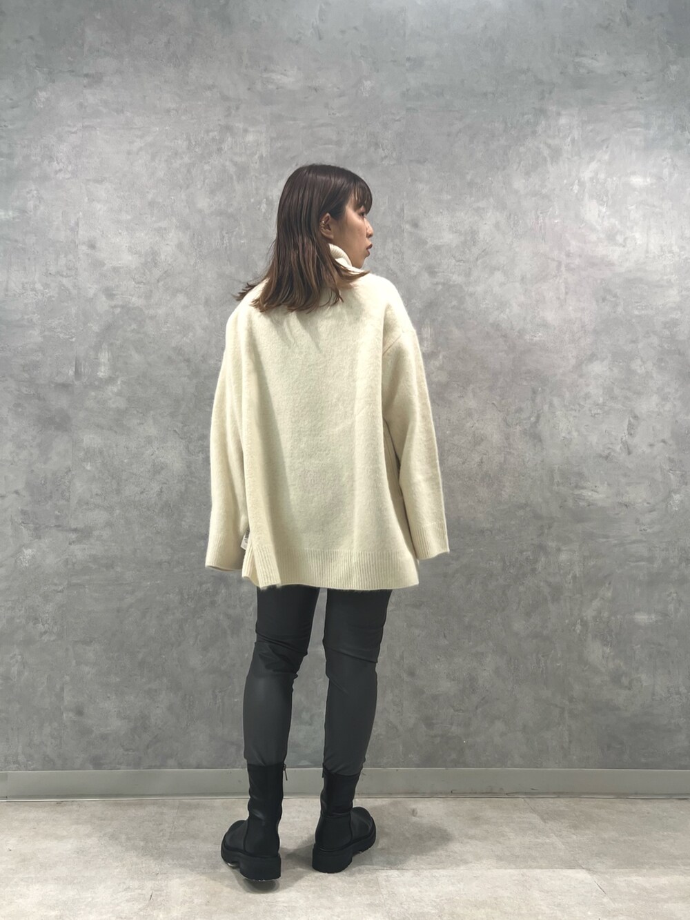 ホワイト系のニット/セーター、グレー系のその他パンツを着用したレディースの秋コーディネートの3枚目の写真