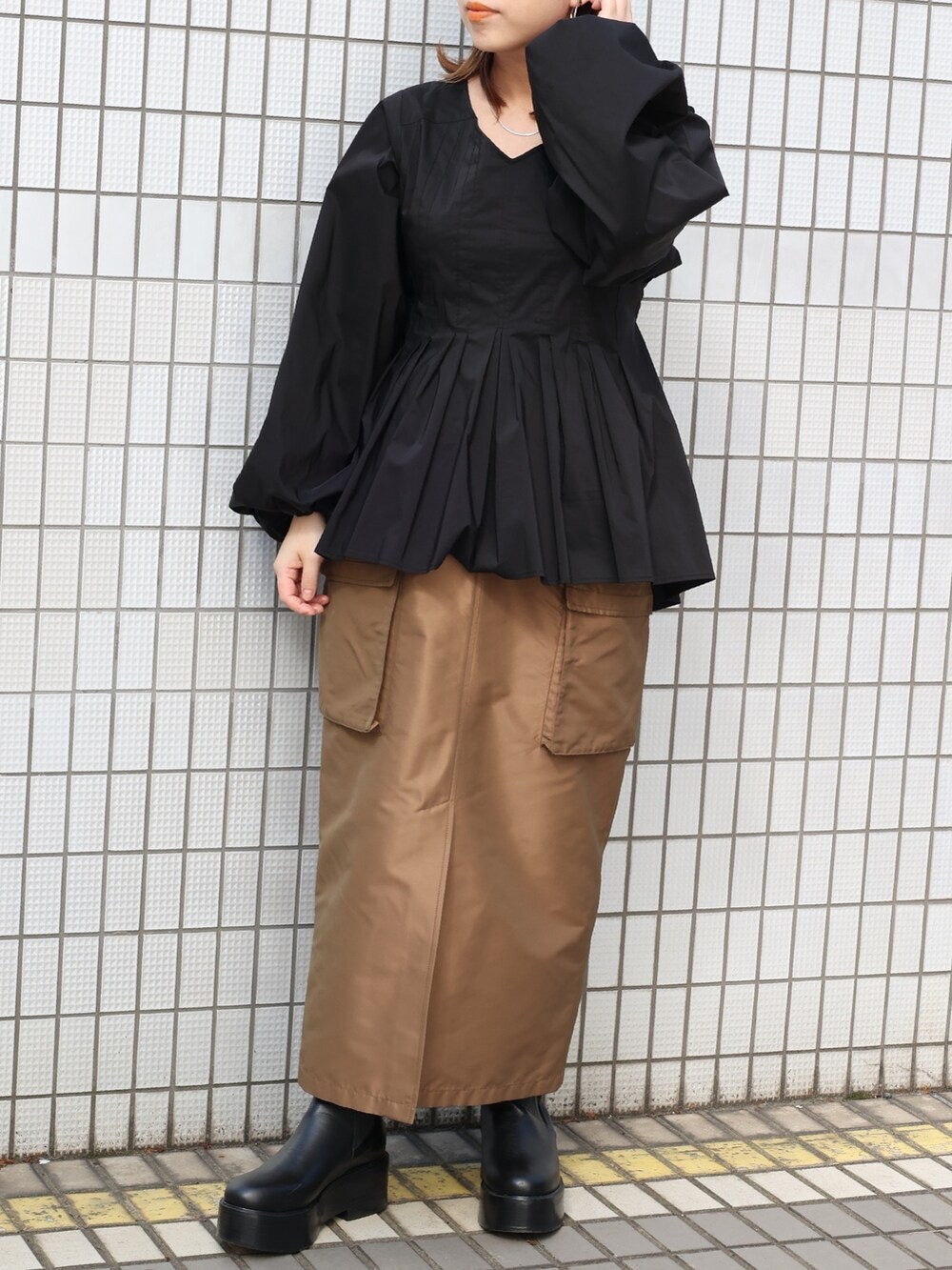 ブラウン系のスカート、ブラック系のシャツ/ブラウスを着用したレディースの春コーディネートの4枚目の写真