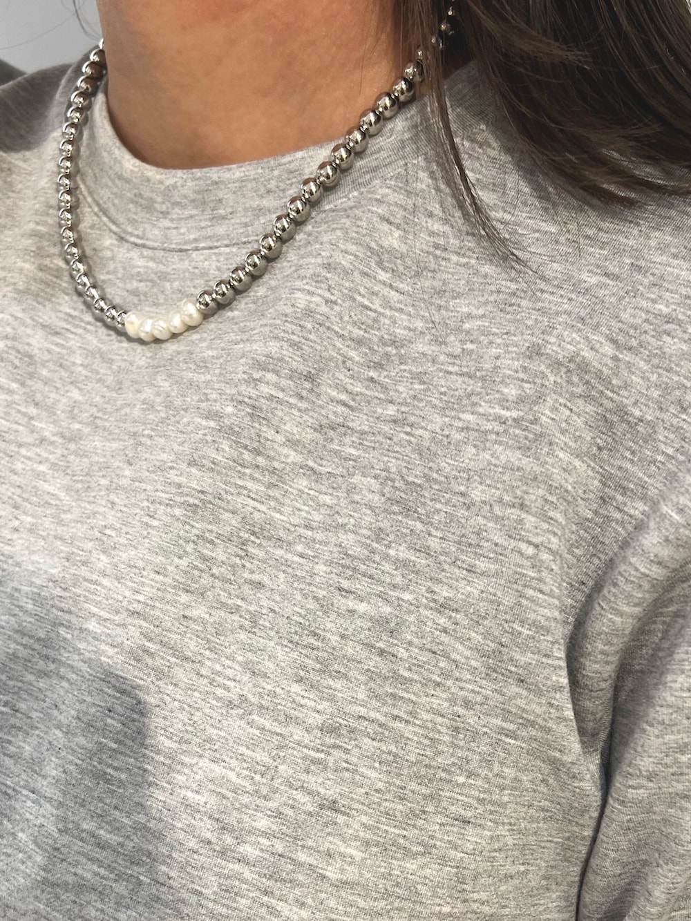 グレー系のTシャツ/カットソー、ブラック系のスカート、ブルー系のスニーカーを着用したレディースの冬コーディネートの8枚目の写真