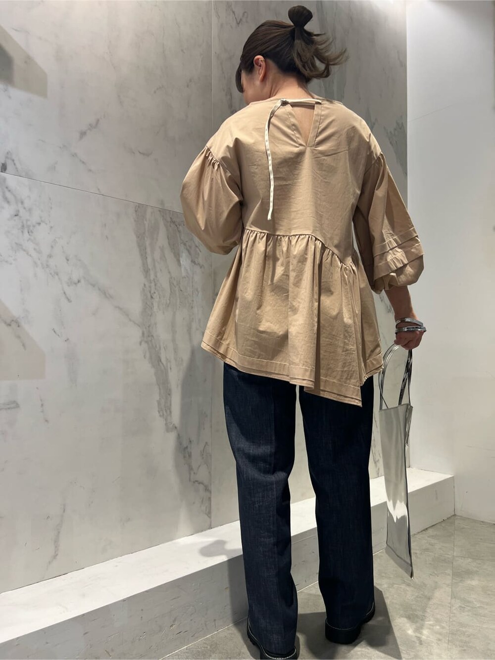 ベージュ系のシャツ/ブラウス、シルバー系のトートバッグ、ブルー系のスラックスを着用したレディースの冬コーディネートの3枚目の写真