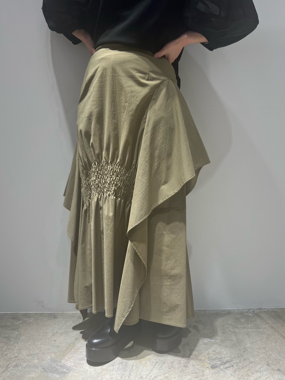 グリーン系のスカート、ブラック系のTシャツ/カットソー、ホワイト系のブーツを着用したレディースの春コーディネートの5枚目の写真